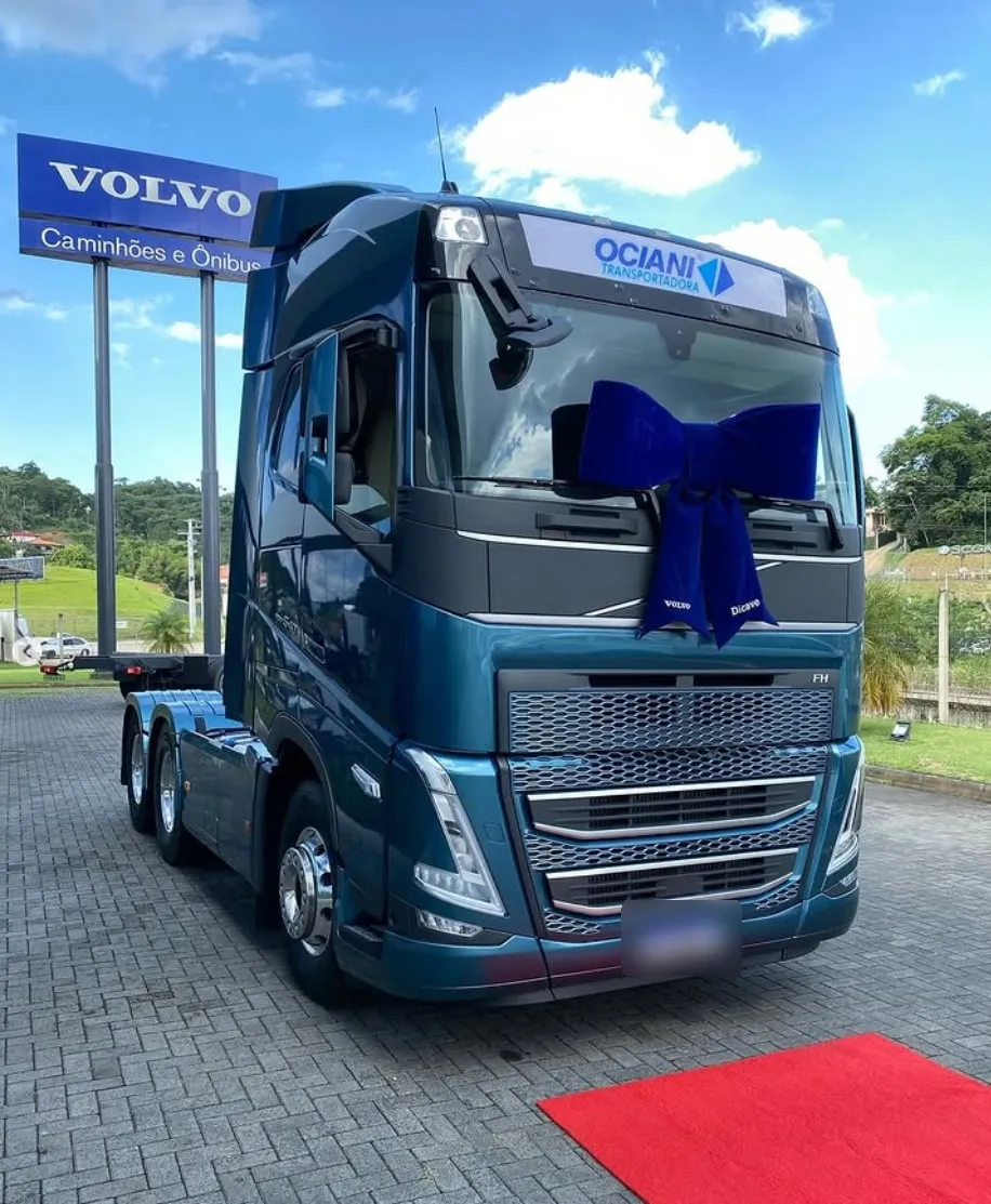Volvo FH novo da Ociani, na cor ciano, com laço de entrega na concessionária