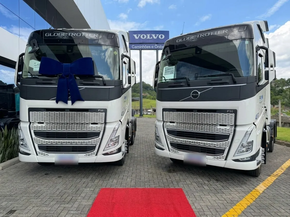 Dois Volvo FH Globetrotter novos da Ociani lado a lado na concessionária, um com laço de entrega