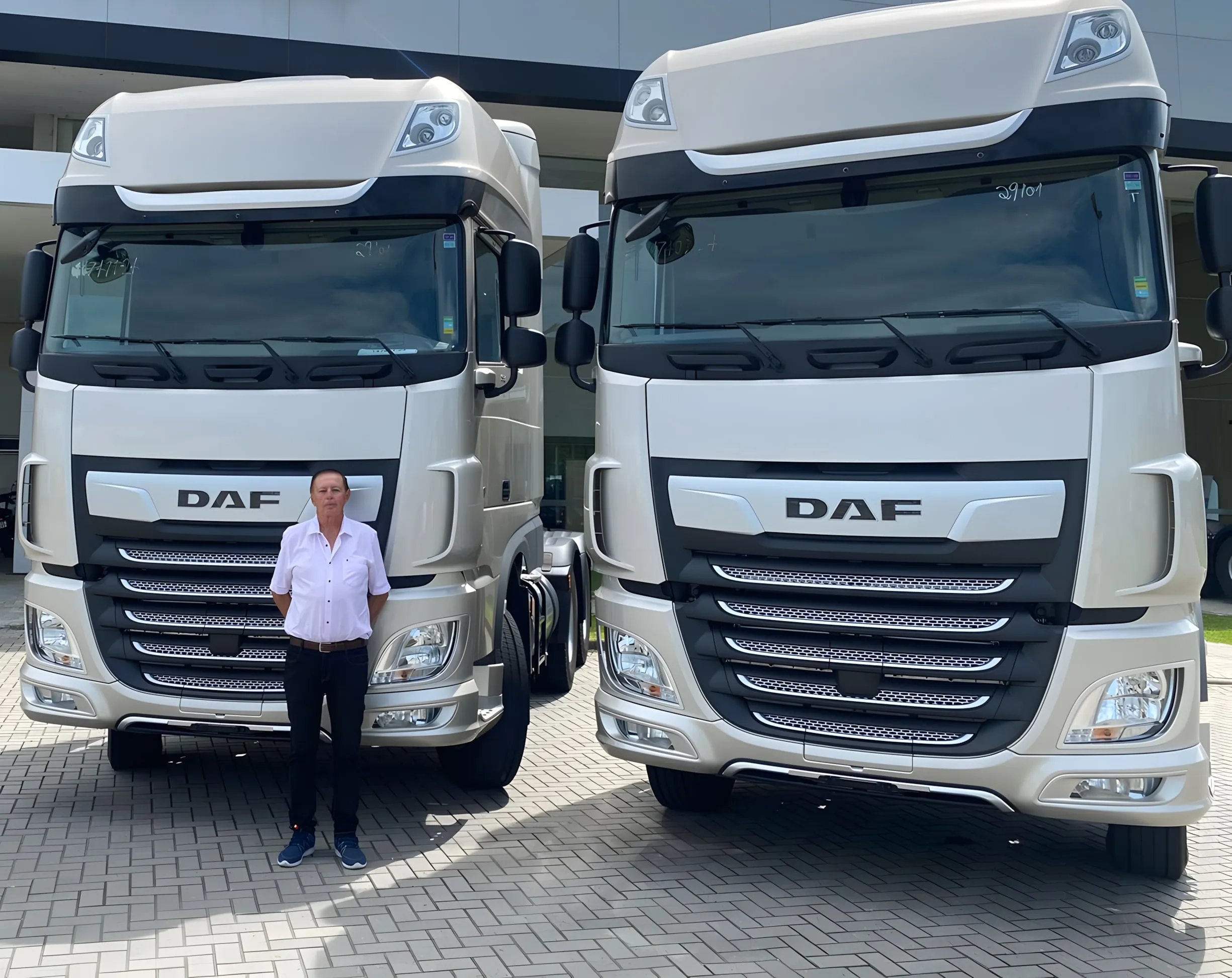 Osvaldo Krauss, fundador da Ociani, em frente a dois caminhões DAF